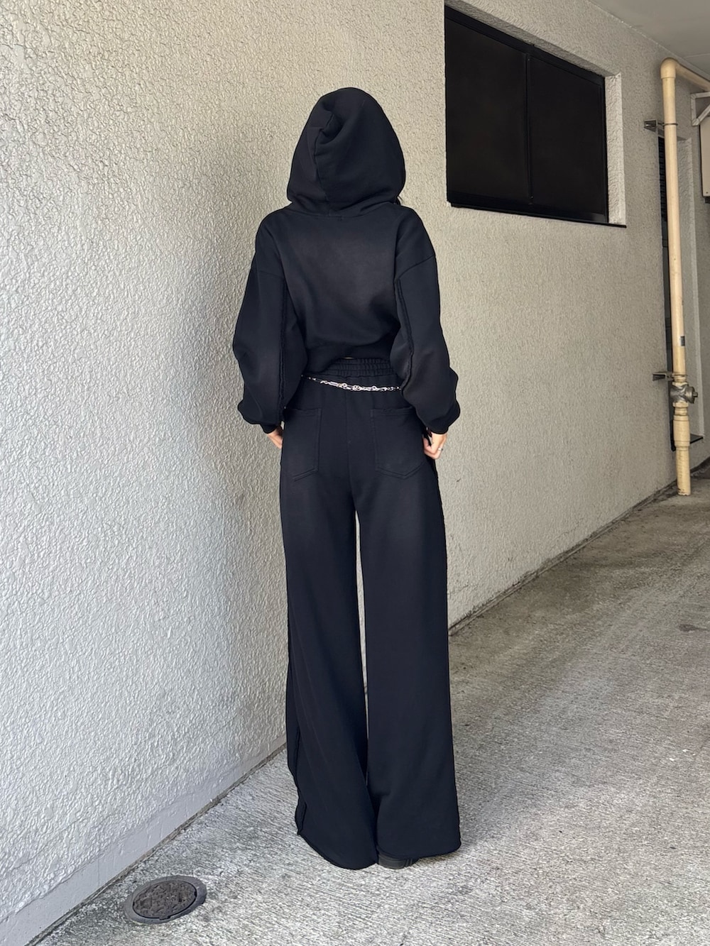 ブラック系のパーカー、ブラック系のスウェットパンツ、シルバー系のベルトを着用したレディースの夏コーディネートの2枚目の写真