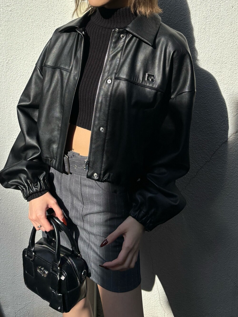 その他のスカート、ブラック系のローファー、ブラック系のハンドバッグを着用したレディースの冬コーディネートの2枚目の写真