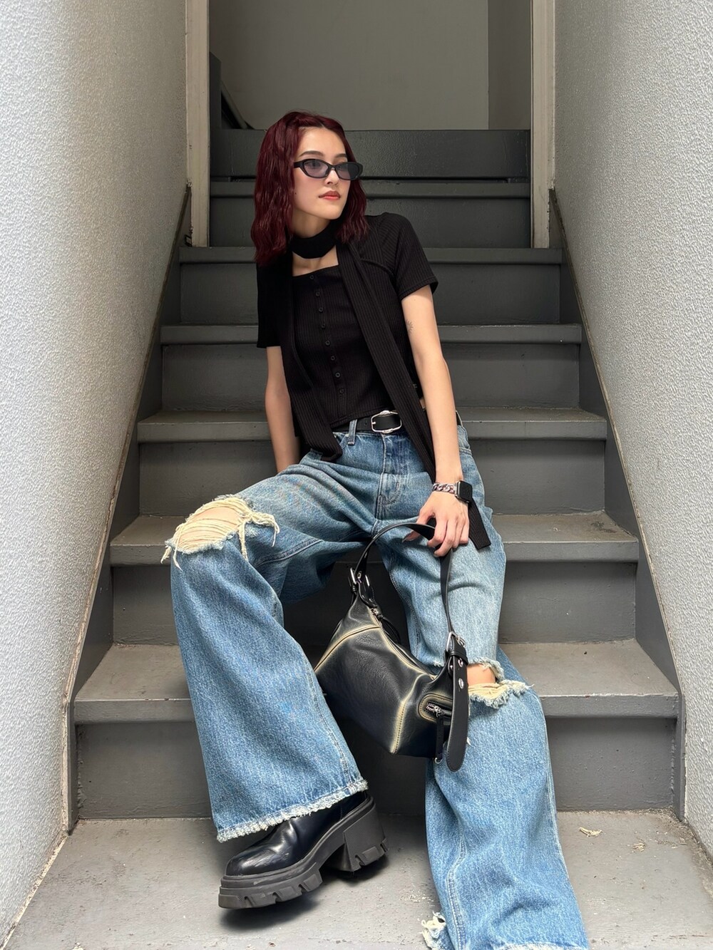 ブラック系のブーツ、ブラック系のハンドバッグ、ブラック系のTシャツ/カットソーを着用したレディースの夏コーディネートの2枚目の写真