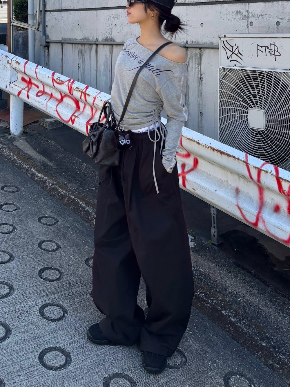 ブラック系のその他パンツ、グレー系のTシャツ/カットソー、ブラック系のスニーカーを着用したレディースの春コーディネートの2枚目の写真