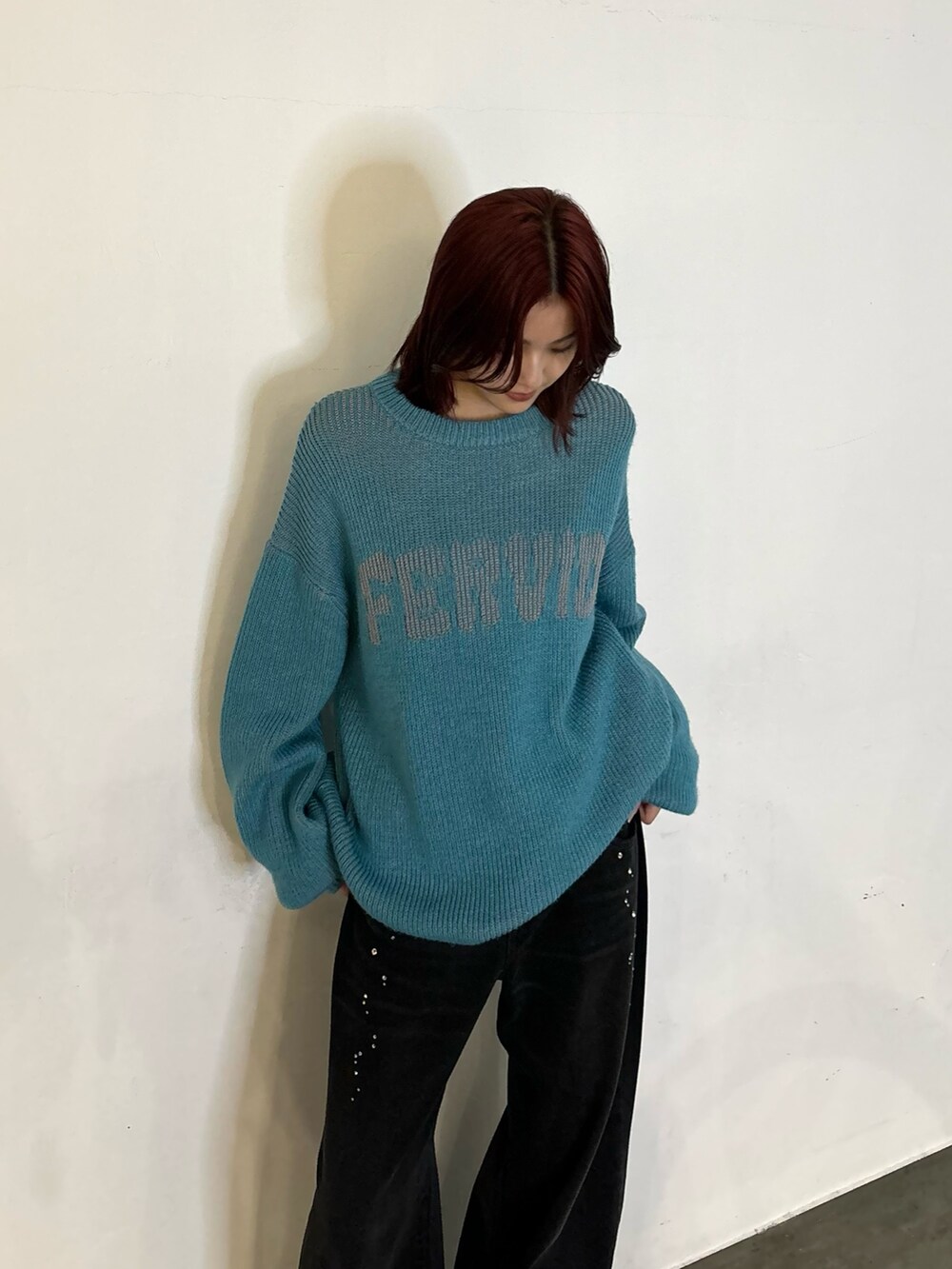 ブラック系のデニムパンツ、ブラック系のローファー、ブルー系のニット/セーターを着用したレディースの秋コーディネートの2枚目の写真