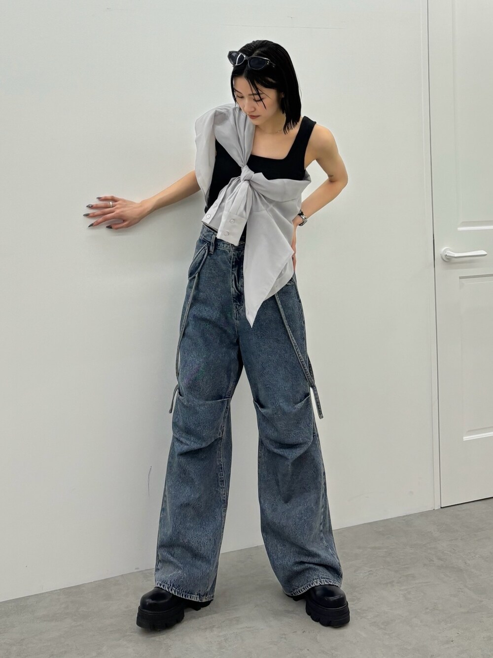 ブルー系のデニムパンツ、ブラック系のタンクトップ、グレー系のシャツ/ブラウスを着用したレディースの春コーディネートの2枚目の写真