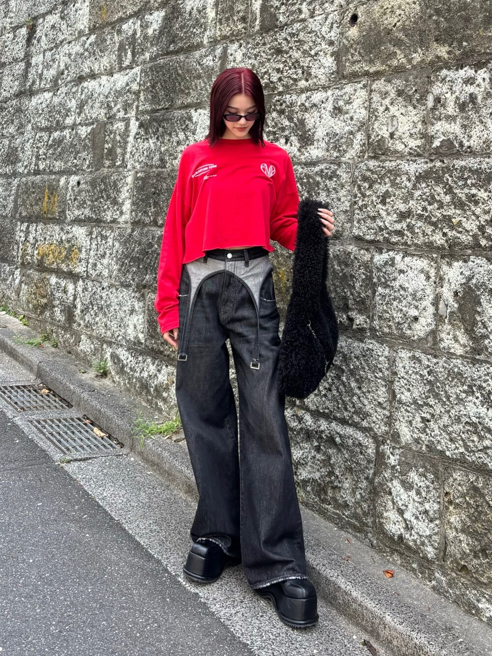 ブラック系のデニムパンツ、ブラック系のローファー、ブラック系のハンドバッグを着用したレディースの秋コーディネートの2枚目の写真