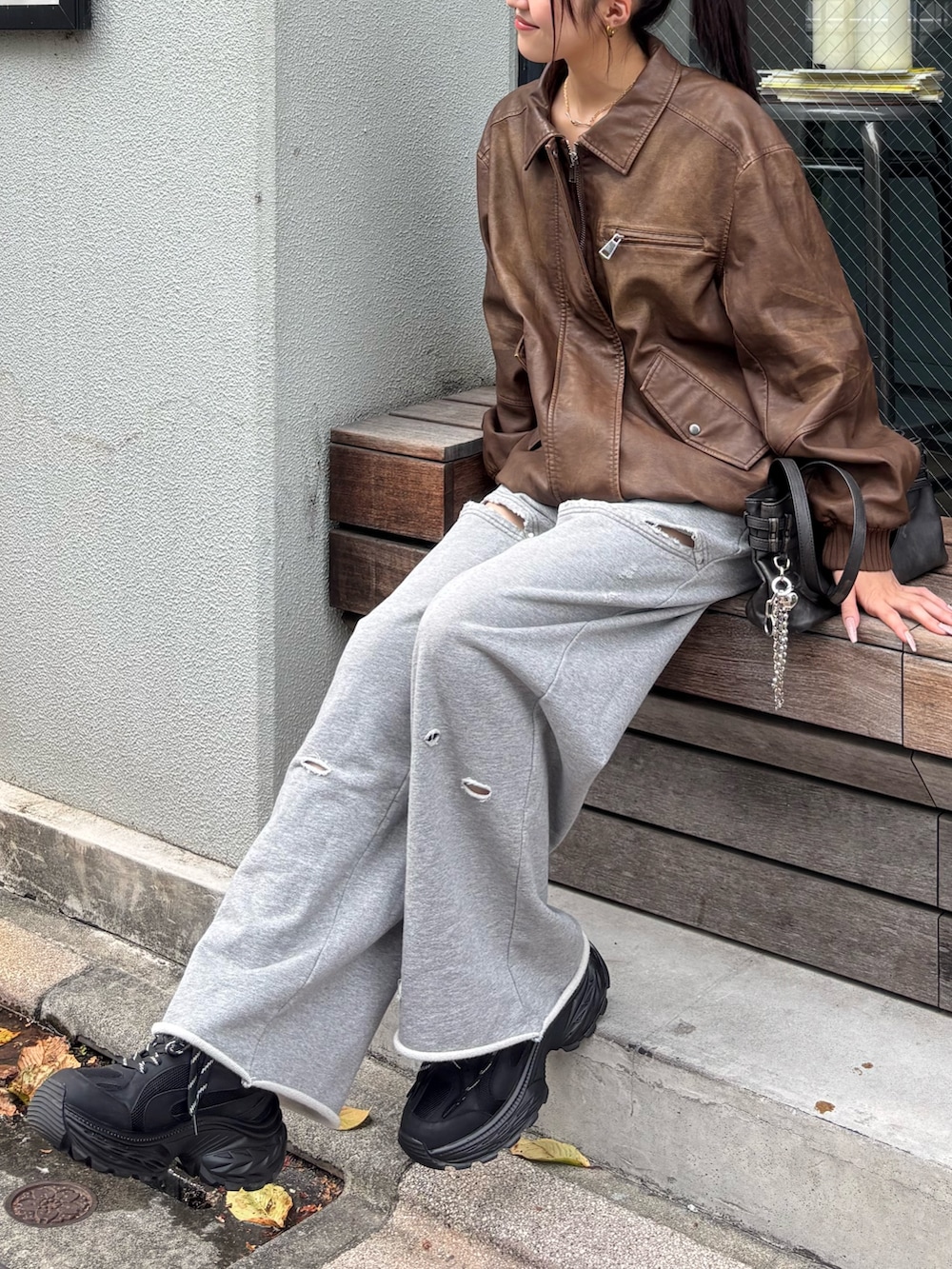 グレー系のスウェットパンツ、ブラック系のスニーカー、ブラック系のショルダーバッグを着用したレディースの夏コーディネートの2枚目の写真