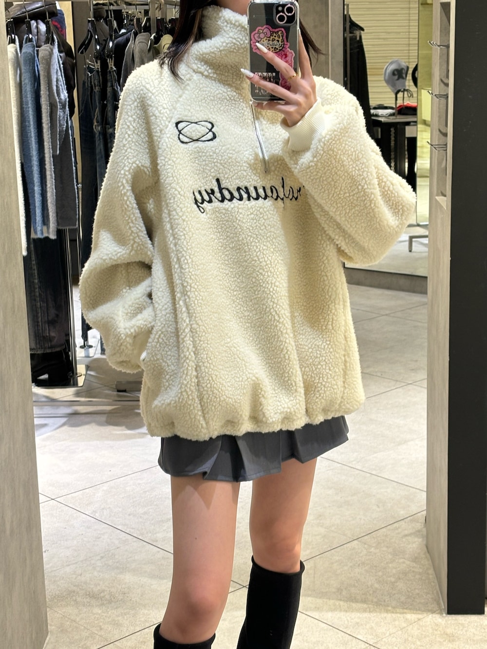 グレー系のスカート、ブラック系のブーツ、ホワイト系のTシャツ/カットソーを着用したレディースの冬コーディネートの2枚目の写真