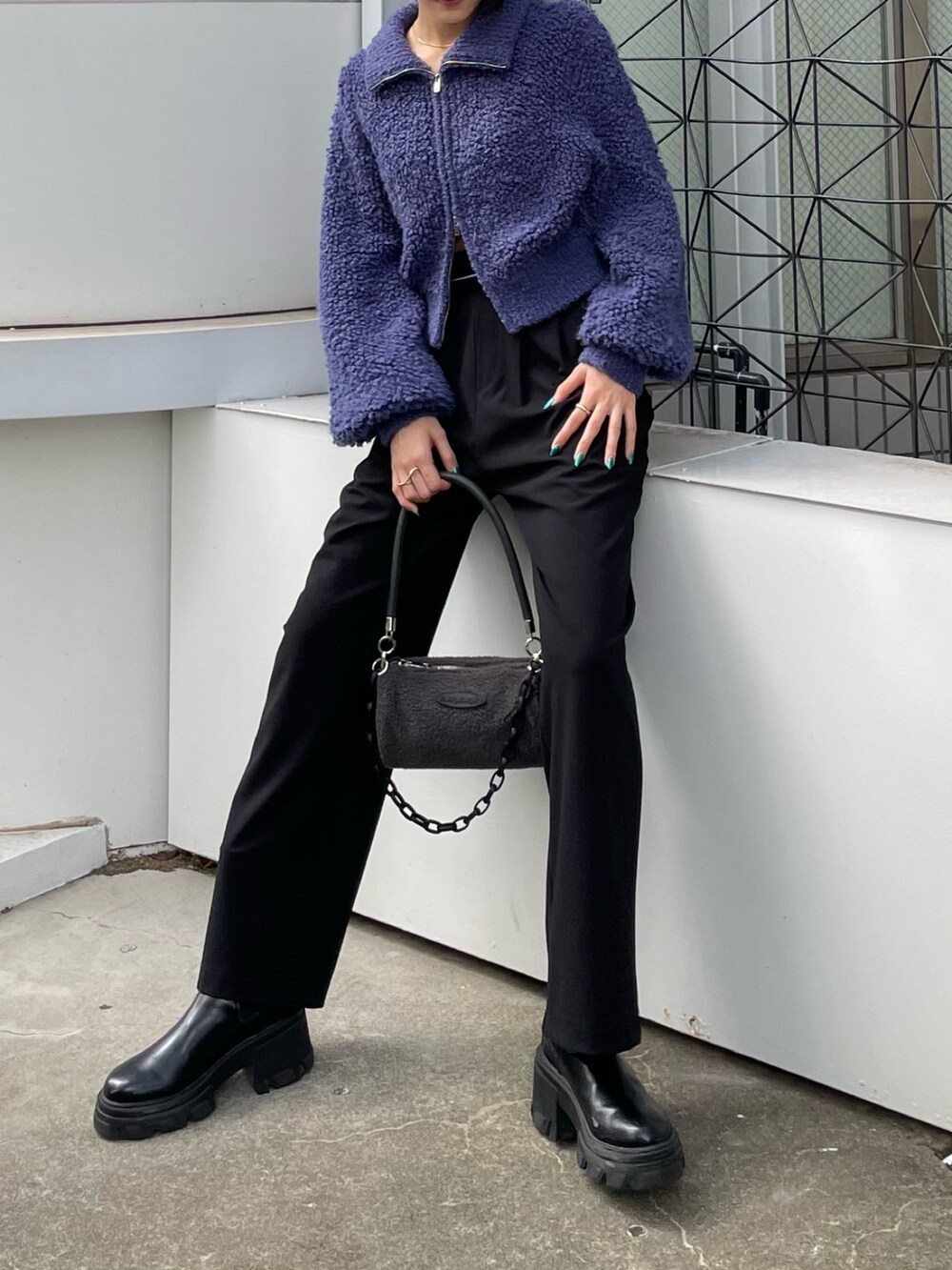 ブラック系のその他パンツ、ブルー系のニット/セーター、グレー系のハンドバッグを着用したレディースの秋コーディネートの2枚目の写真