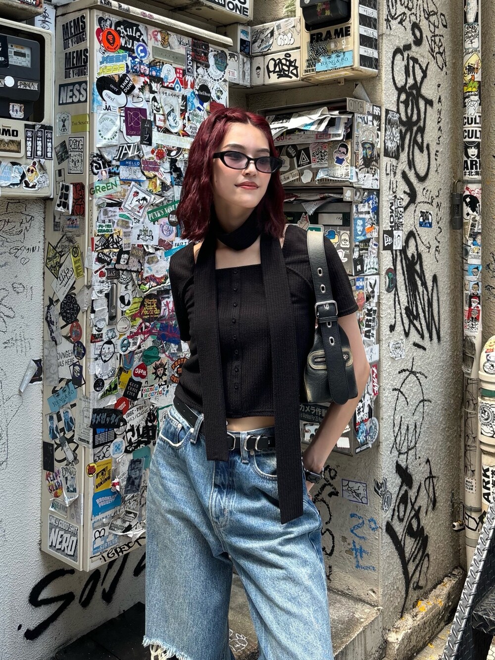 ブラック系のTシャツ/カットソー、ブラック系のハンドバッグ、ブラック系のサングラスを着用したレディースの夏コーディネートの2枚目の写真