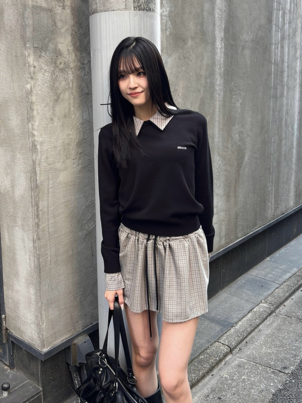 ブラック系のスカート、ブラック系のニット/セーター、ブラック系のトートバッグを着用したレディースの冬コーディネートの2枚目の写真