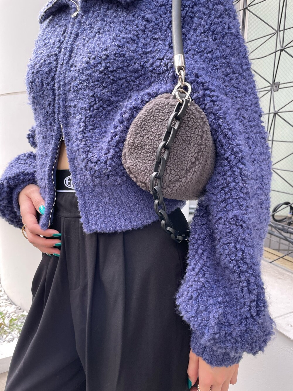 ブラック系のその他パンツ、ブルー系のニット/セーター、グレー系のハンドバッグを着用したレディースの秋コーディネートの3枚目の写真