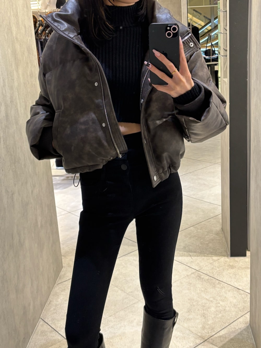 ブラック系のデニムパンツ、ブラック系のブーツ、ブラウン系のダウンジャケット/コートを着用したレディースの冬コーディネートの2枚目の写真