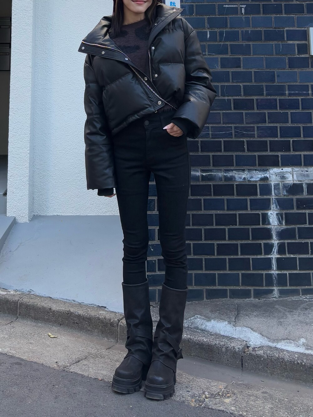 ブラック系のデニムパンツ、ブラック系のブーツ、ブラック系のダウンジャケット/コートを着用したレディースの冬コーディネートの2枚目の写真