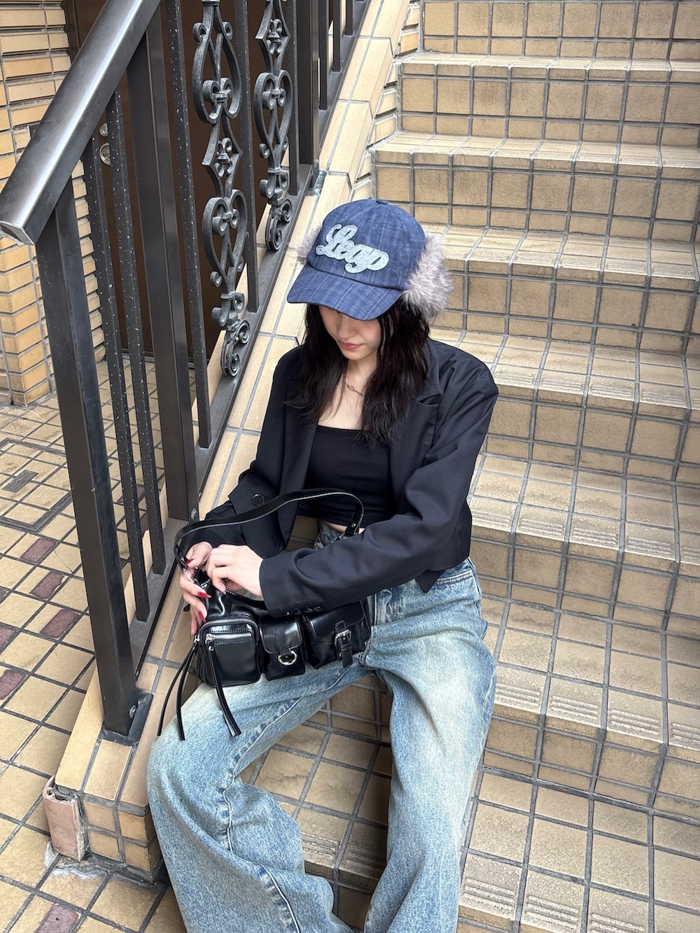 ブラック系のキャミソール、ブラック系のテーラードジャケット、ブルー系のデニムパンツを着用したレディースの秋コーディネートの2枚目の写真