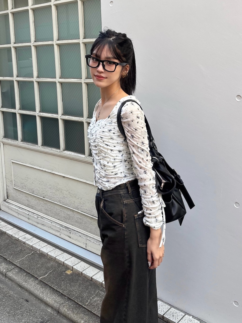 ホワイト系のTシャツ/カットソー、ブラック系のトートバッグ、ブルー系のデニムパンツを着用したレディースの冬コーディネートの2枚目の写真