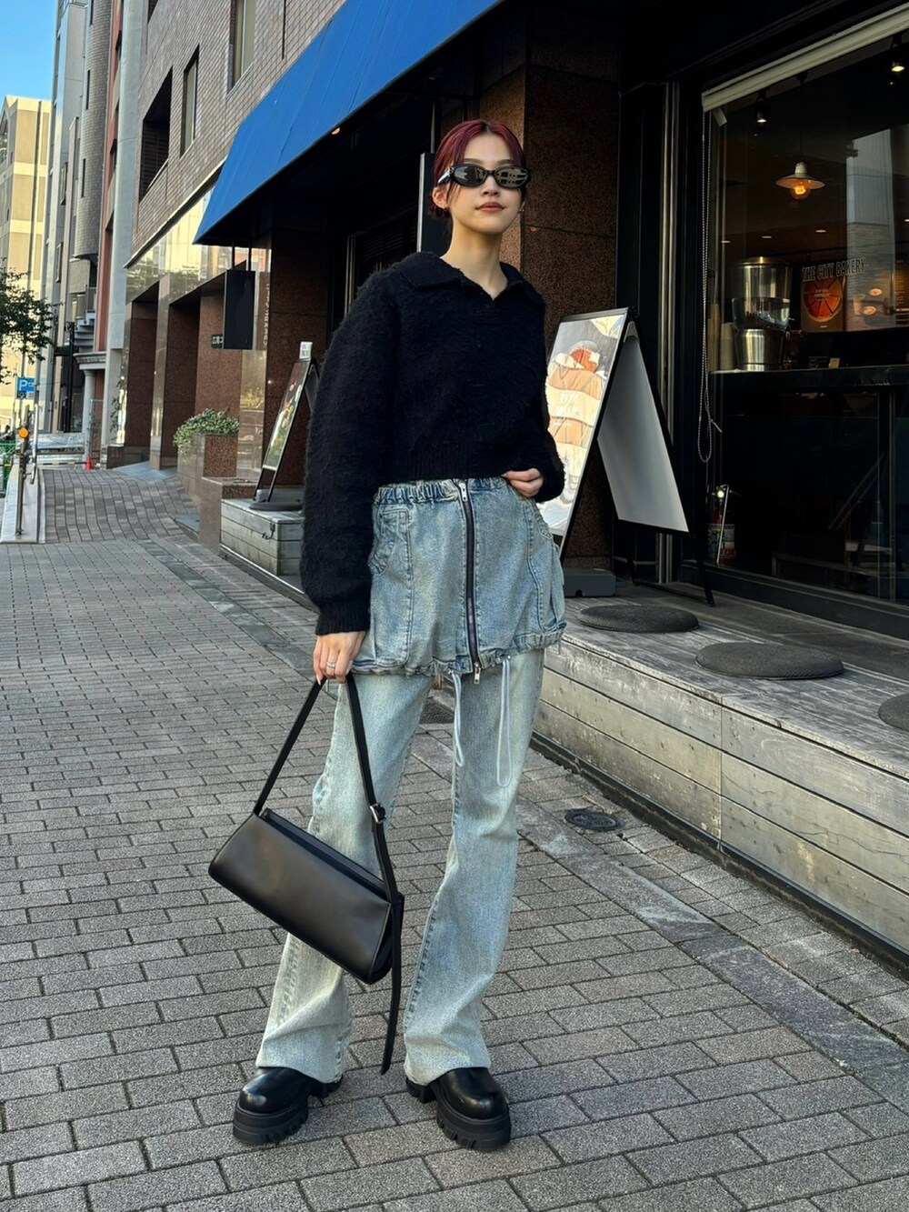 ブルー系のデニムパンツ、ブラック系のブーツ、ブラック系のニット/セーターを着用したレディースの秋コーディネートの3枚目の写真