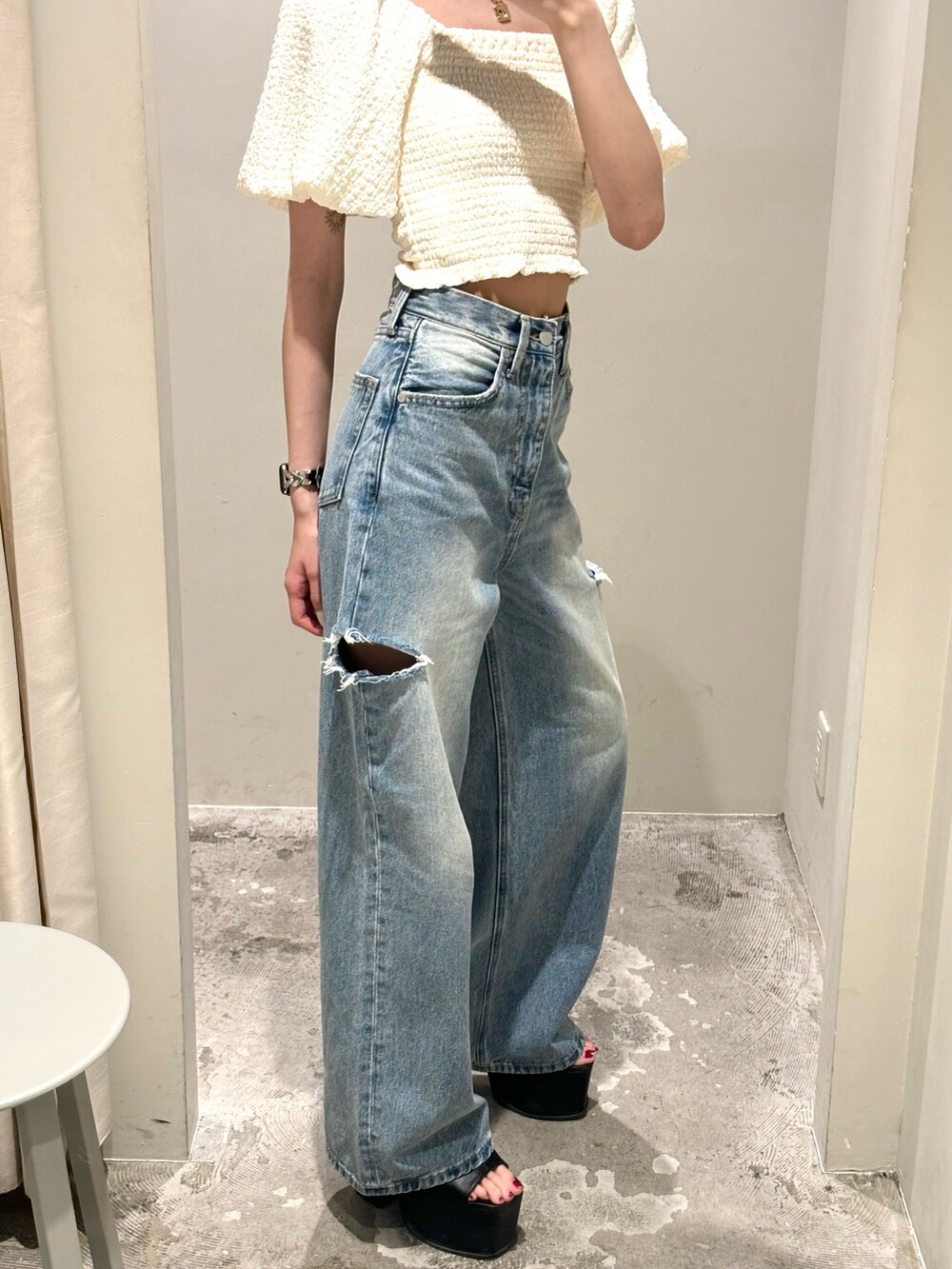 ブルー系のデニムパンツ、ホワイト系のTシャツ/カットソー、ブラック系のサンダルを着用したレディースの夏コーディネートの2枚目の写真