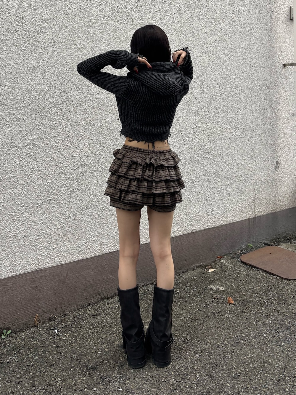 ブラック系のブーツ、ブラウン系のその他パンツ、ブラック系のニット/セーターを着用したレディースの秋コーディネートの2枚目の写真