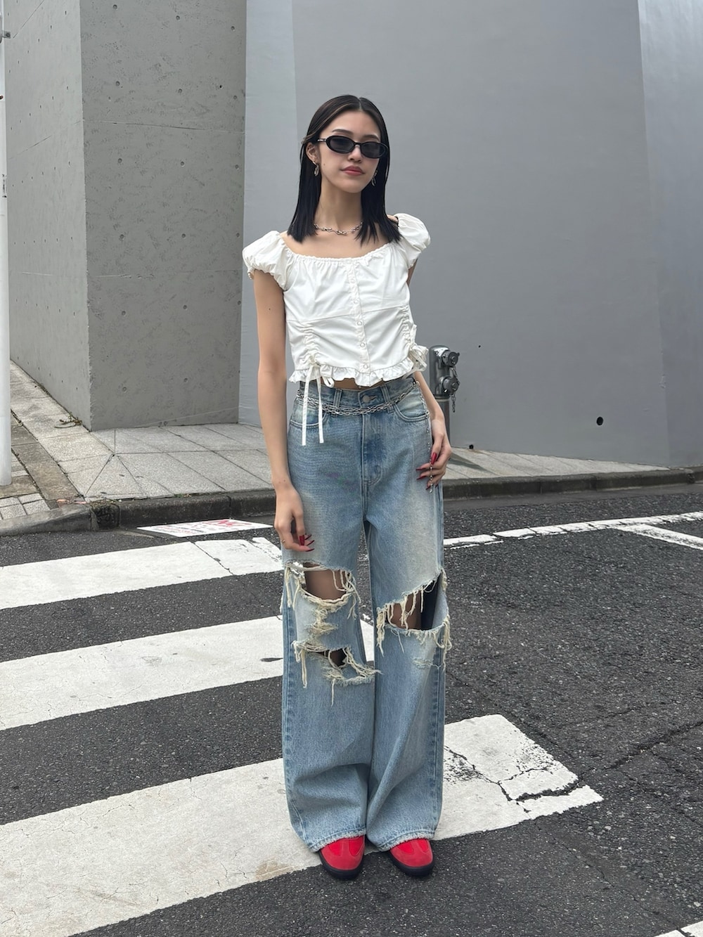 ブルー系のデニムパンツ、レッド系のスニーカー、ホワイト系のTシャツ/カットソーを着用したレディースの冬コーディネートの2枚目の写真