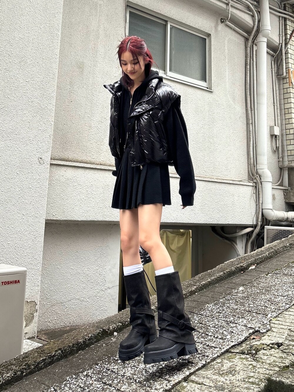 ブラック系のブーツ、ブラック系のスカート、ブラック系のニット/セーターを着用したレディースの秋コーディネートの2枚目の写真