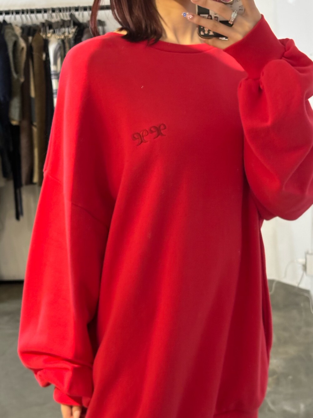 レッド系のスウェット、ブラック系のブーツを着用したレディースの秋コーディネートの2枚目の写真