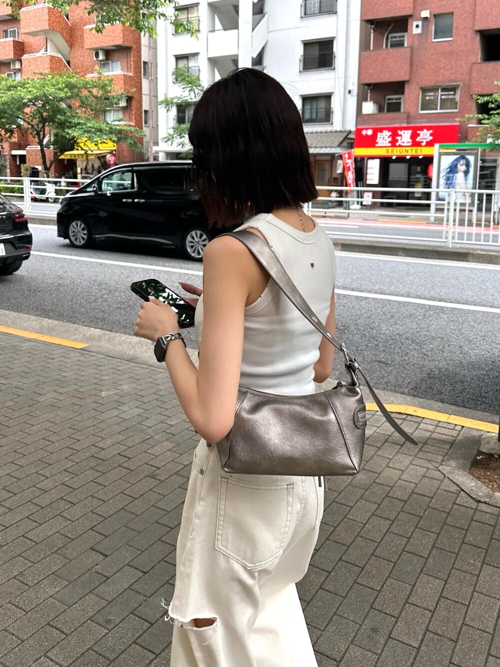 ホワイト系のタンクトップ、ホワイト系のデニムパンツ、シルバー系のネックレスを着用したレディースの夏コーディネートの2枚目の写真