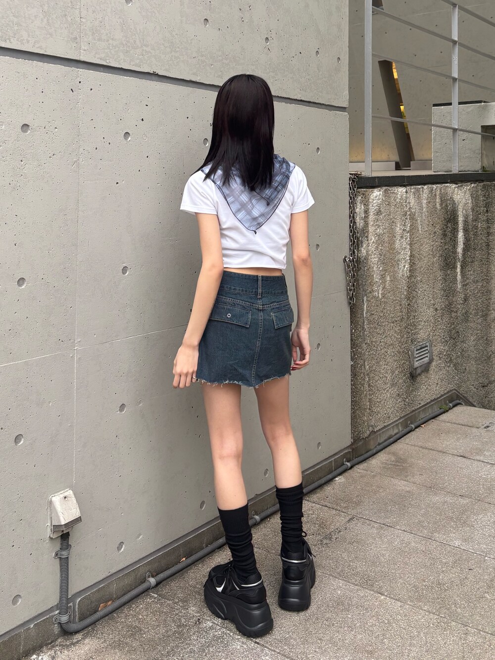 ホワイト系のTシャツ/カットソー、ブルー系のスカート、ブラック系のスニーカーを着用したレディースの冬コーディネートの2枚目の写真