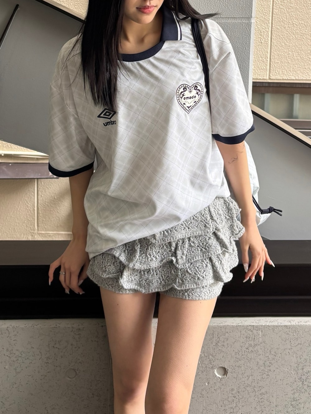 ホワイト系のTシャツ/カットソー、グレー系のスカート、ホワイト系のバックパック/リュックを着用したレディースの冬コーディネートの2枚目の写真