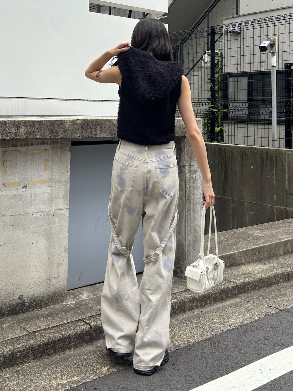 ホワイト系のデニムパンツ、ブラック系のサンダル、ブラック系のニット/セーターを着用したレディースの春コーディネートの2枚目の写真