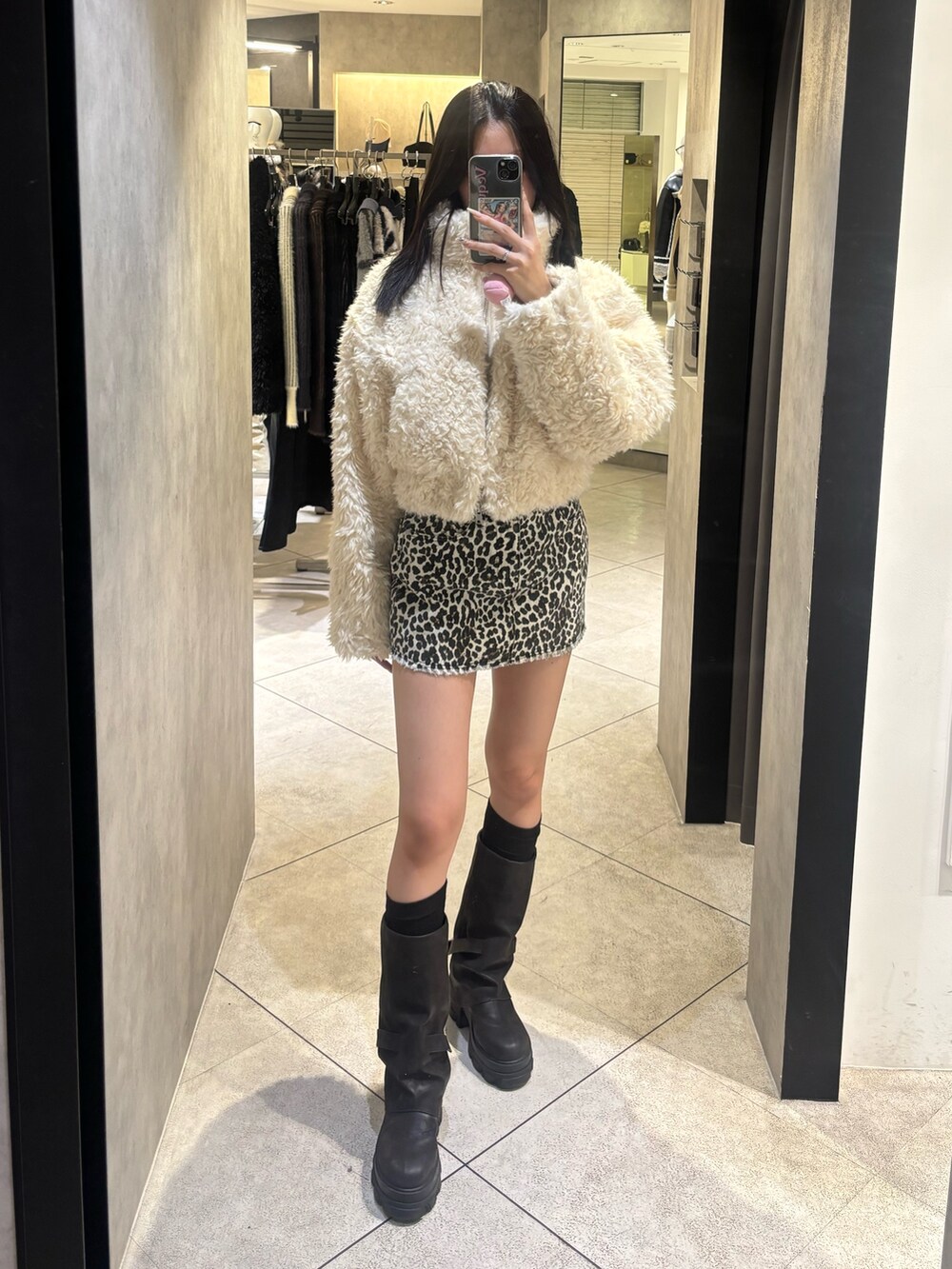 ホワイト系のスカート、ブラック系のブーツ、ホワイト系のブルゾンを着用したレディースの秋コーディネートの2枚目の写真