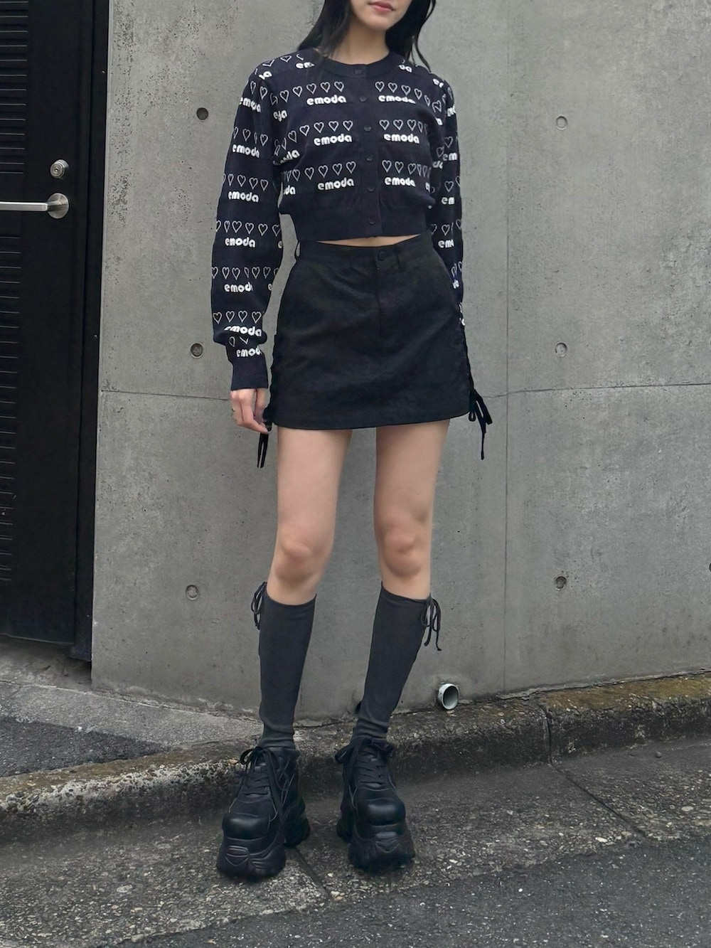 ブラック系のスカート、ブラック系のスニーカー、ブルー系のニット/セーターを着用したレディースの冬コーディネートの2枚目の写真