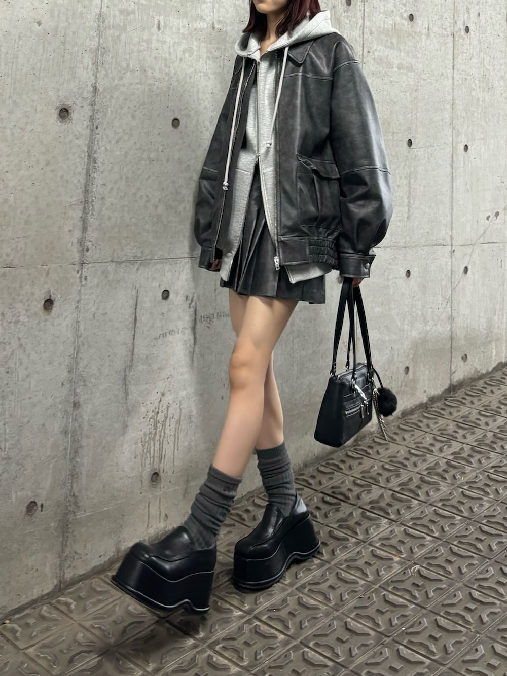 グレー系のブルゾン、グレー系のパーカー、グレー系のスカートを着用したレディースの秋コーディネートの2枚目の写真