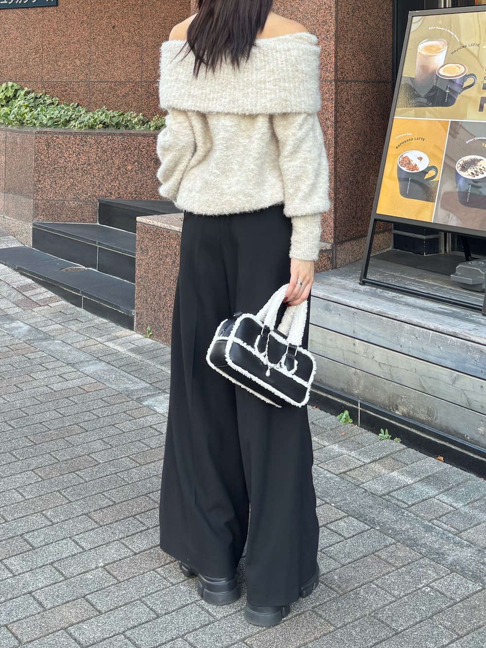 ホワイト系のニット/セーター、ブラック系のその他パンツ、ブラック系のハンドバッグを着用したレディースの秋コーディネートの2枚目の写真