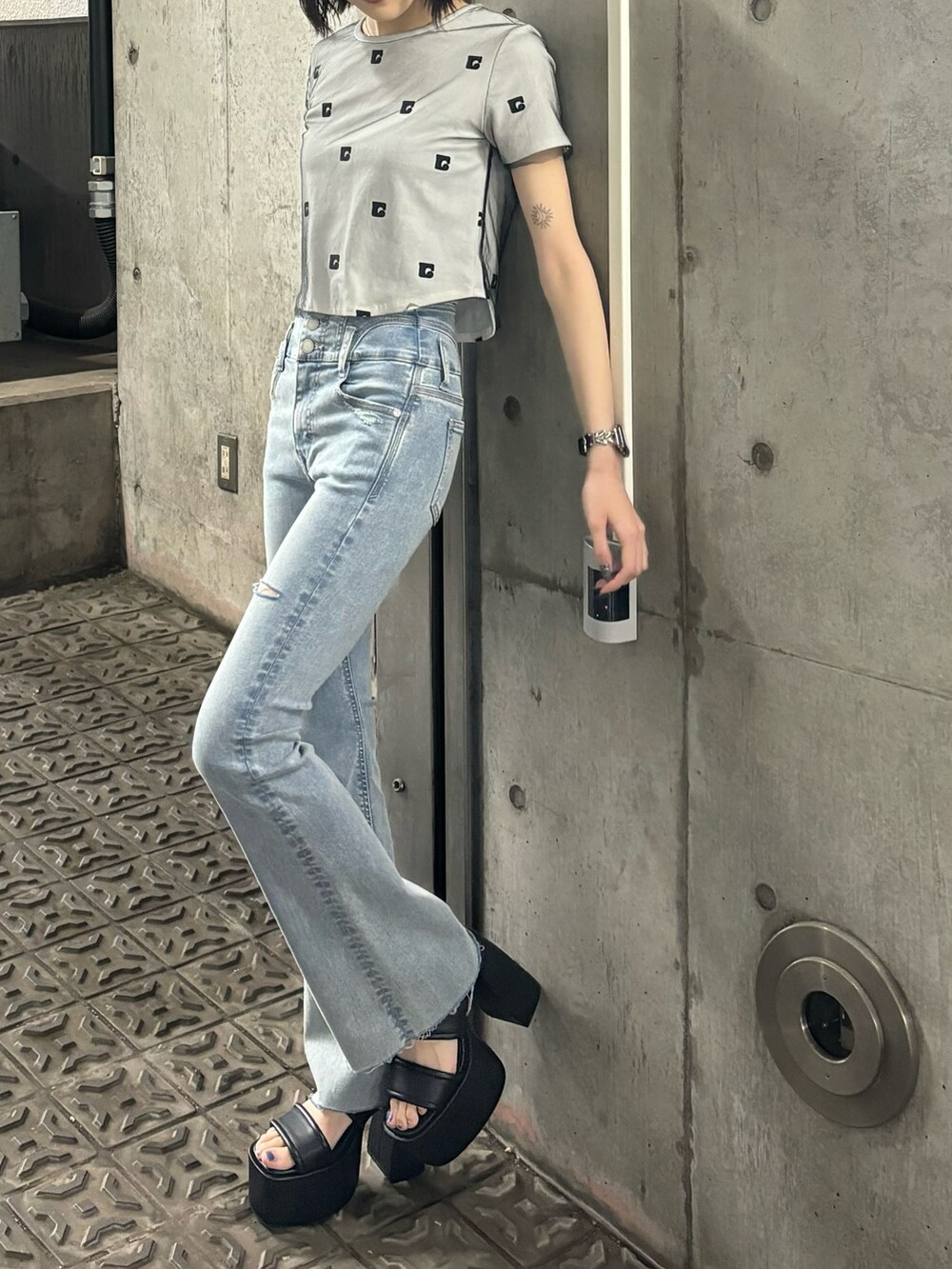 ブルー系のデニムパンツ、ホワイト系のTシャツ/カットソー、ブラック系のサンダルを着用したレディースの春コーディネートの2枚目の写真