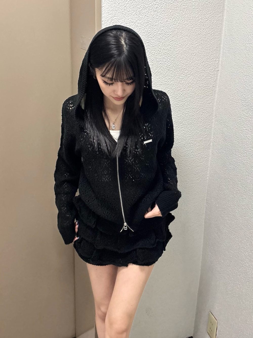 ブラック系のパーカー、ブラック系のスカート、ブラック系のスニーカーを着用したレディースの冬コーディネートの2枚目の写真