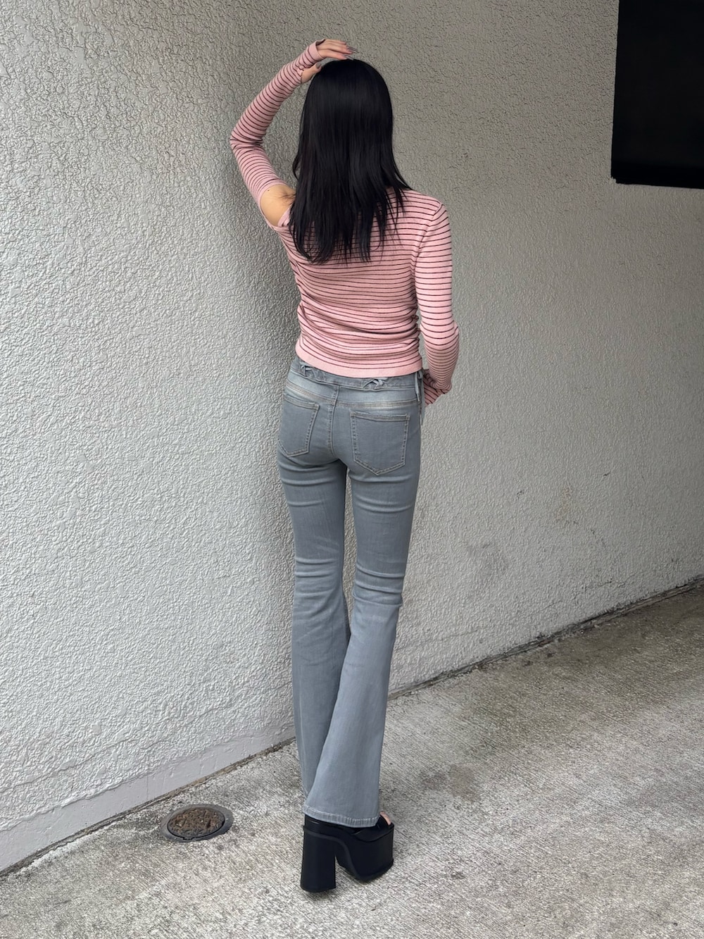 ピンク系のニット/セーター、グレー系のデニムパンツ、ブラック系のサンダルを着用したレディースの冬コーディネートの2枚目の写真