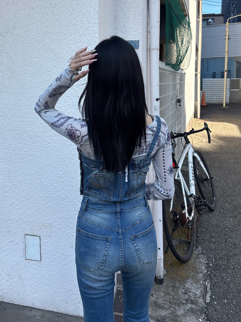 ホワイト系のサンダル、ブルー系のサロペット/オーバーオール、ホワイト系のTシャツ/カットソーを着用したレディースの春コーディネートの3枚目の写真