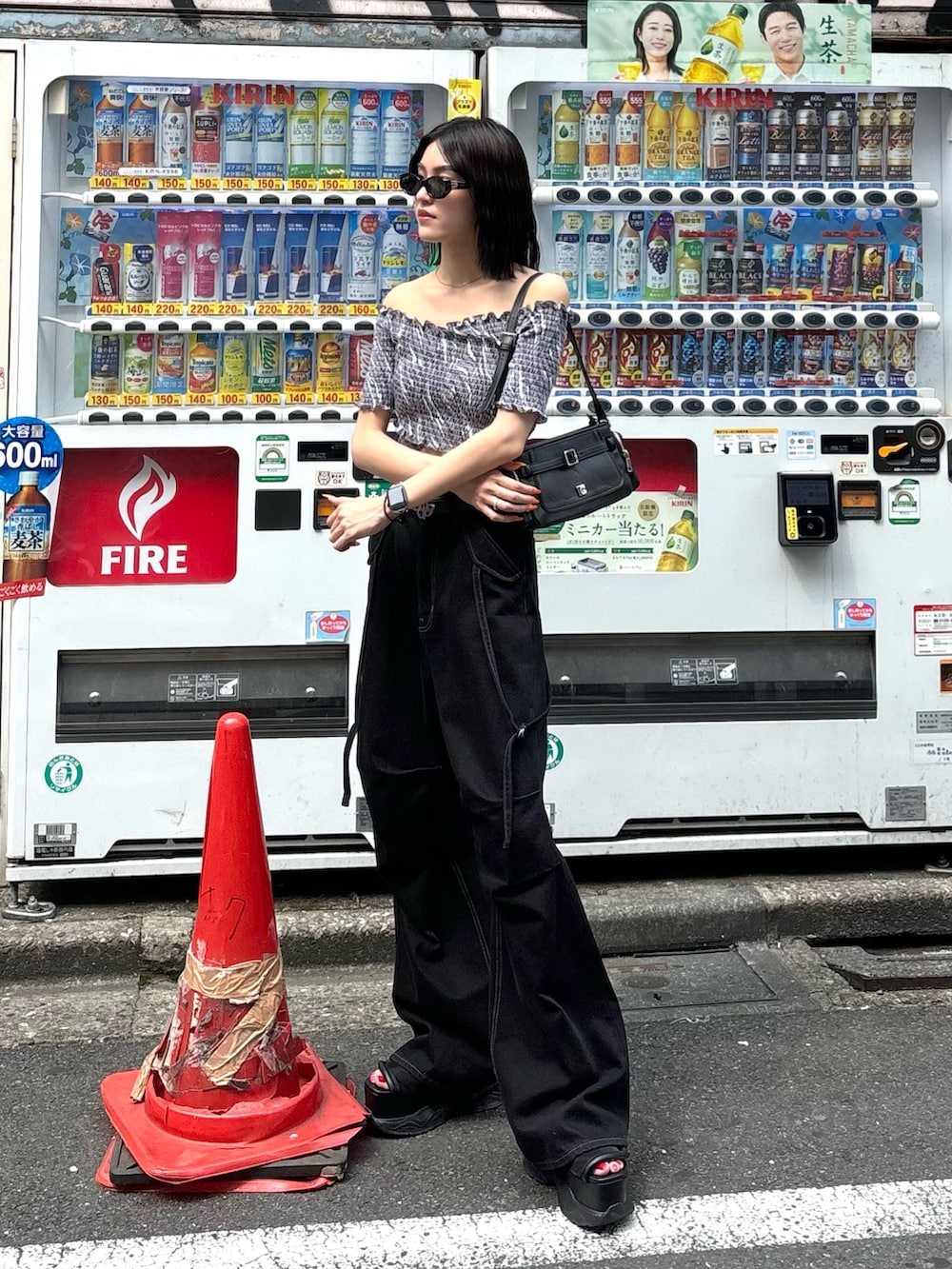 ブラック系のデニムパンツ、ブラック系のサンダル、ブラック系のショルダーバッグを着用したレディースの夏コーディネートの2枚目の写真