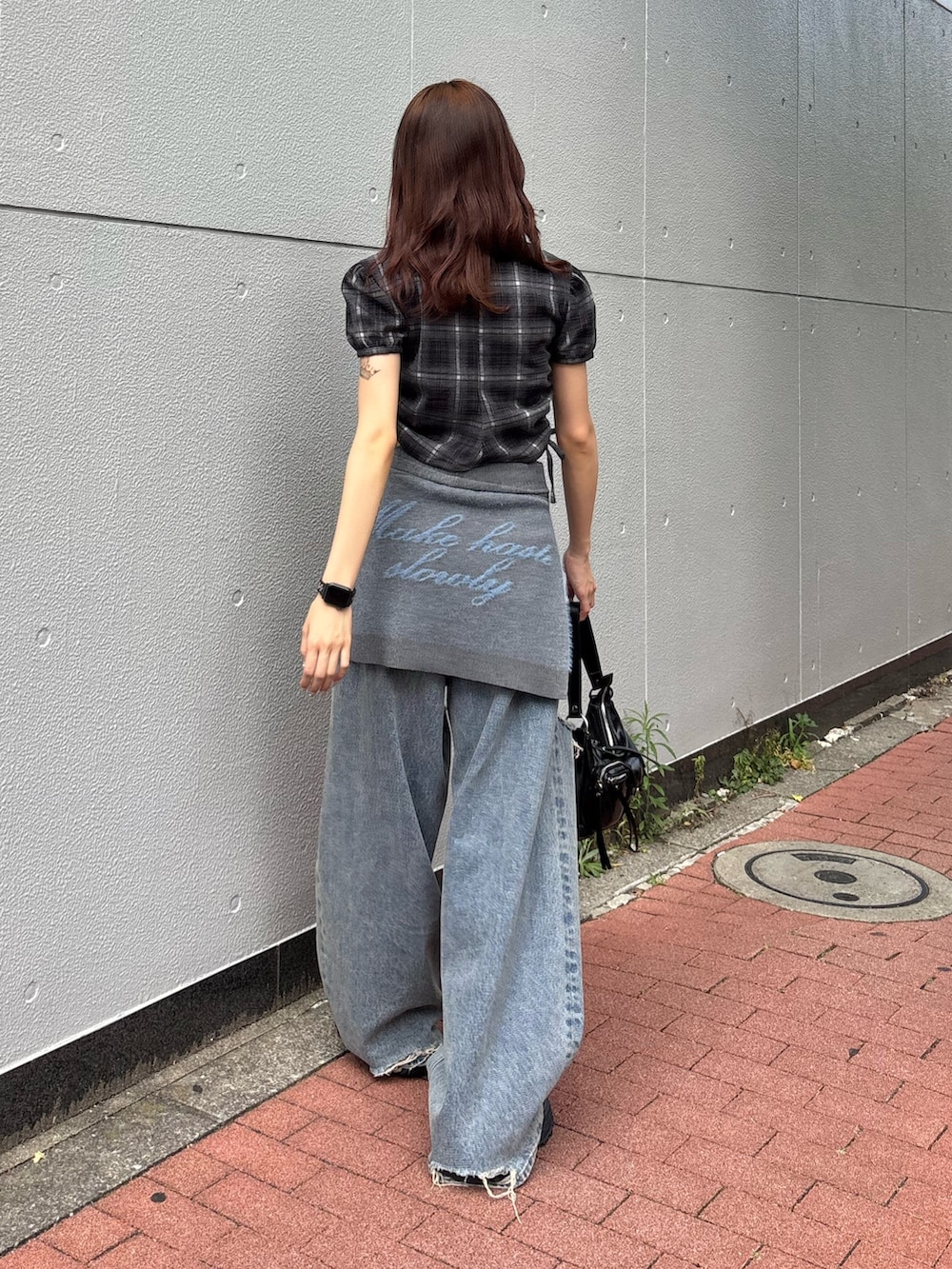 ブラック系のスニーカー、ブラック系のハンドバッグ、ブルー系のデニムパンツを着用したレディースの夏コーディネートの2枚目の写真