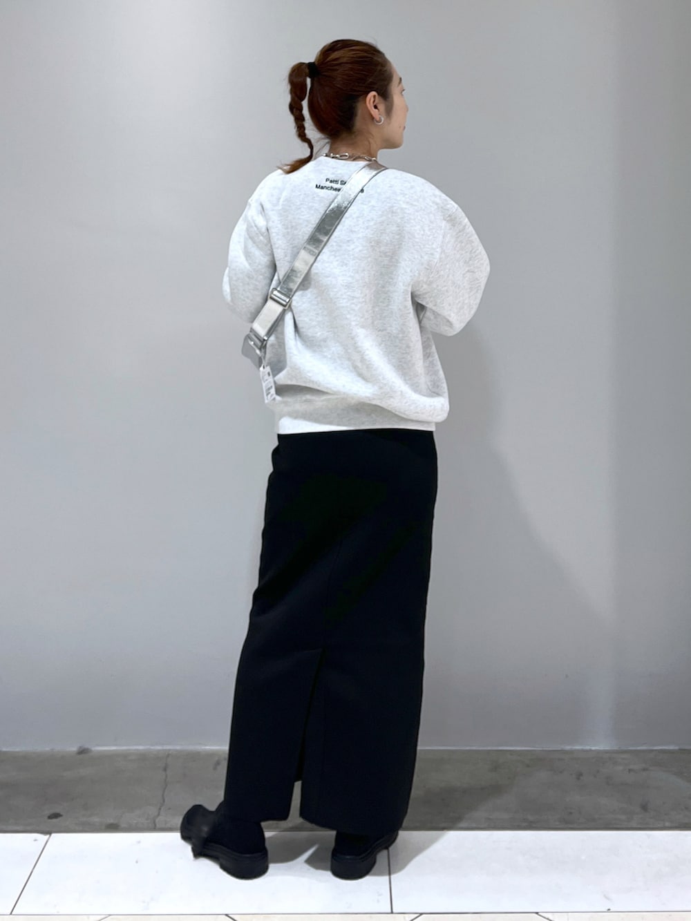ブラック系のスカート、シルバー系のショルダーバッグ、グレー系のスウェットを着用したレディースの冬コーディネートの3枚目の写真