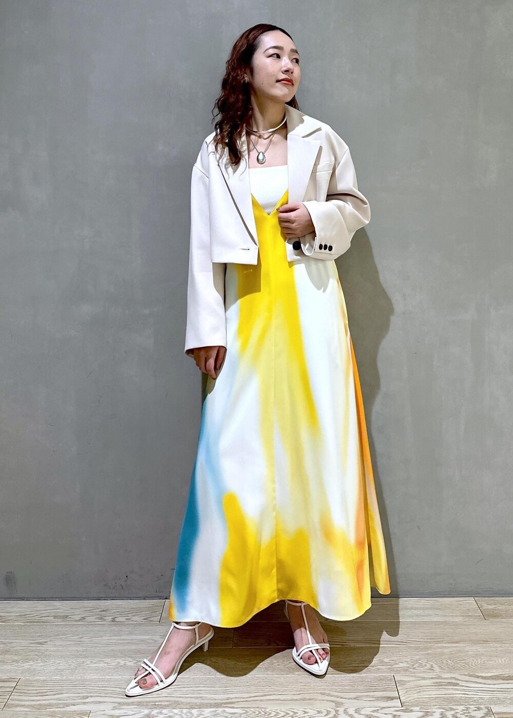 ホワイト系のサンダル、イエロー系のワンピース、ホワイト系のテーラードジャケットを着用したレディースの春コーディネートの3枚目の写真