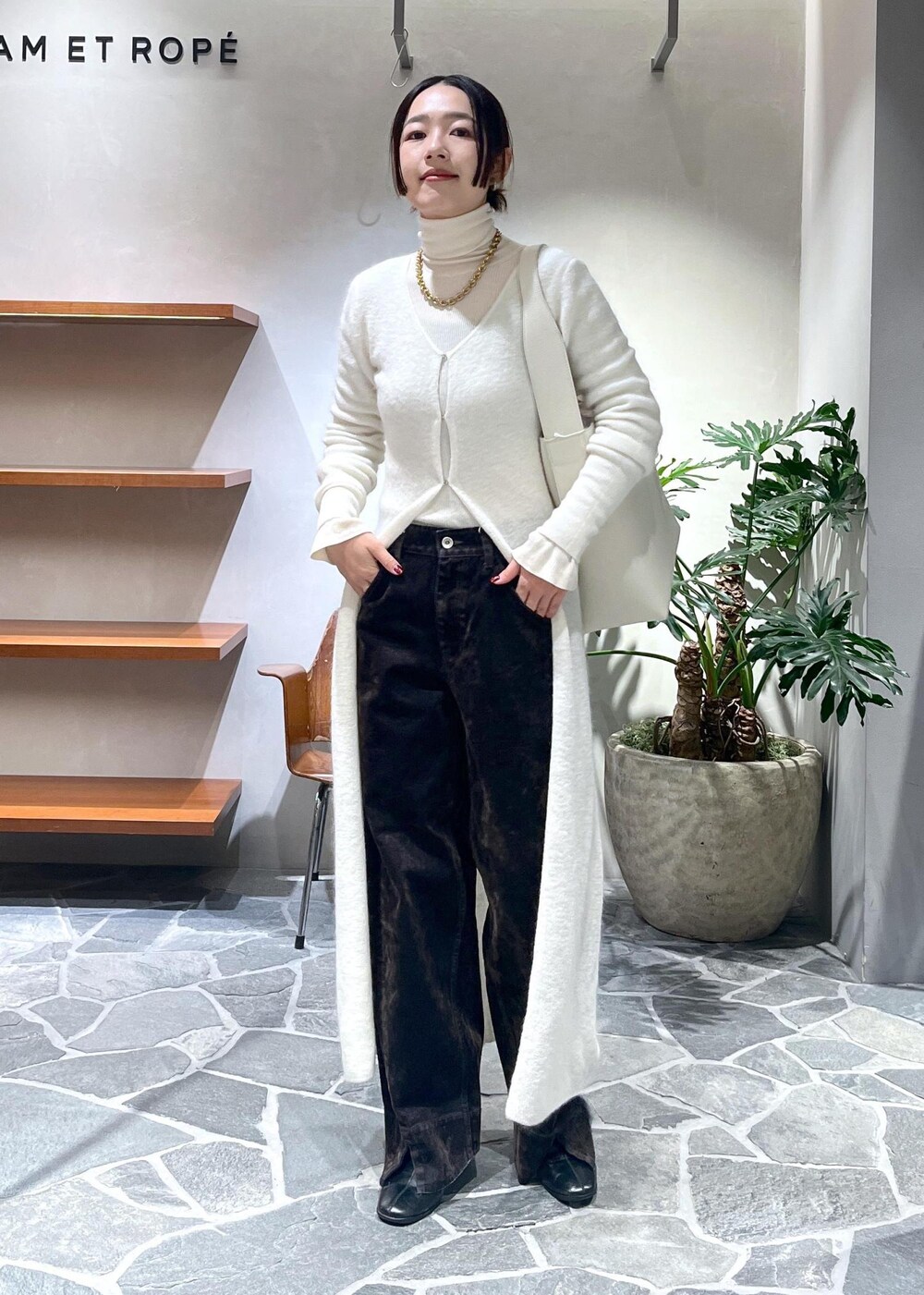 ホワイト系のカーディガン/ボレロ、ブラウン系のデニムパンツを着用したレディースの冬コーディネートの2枚目の写真