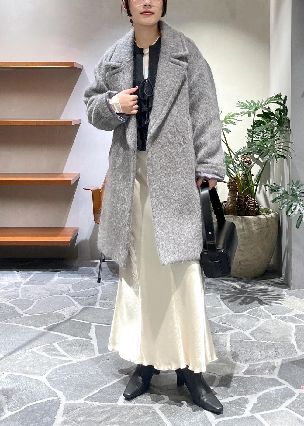 ブラック系のブーツ、ベージュ系のスカート、ブラック系のカーディガン/ボレロを着用したレディースの冬コーディネートの4枚目の写真