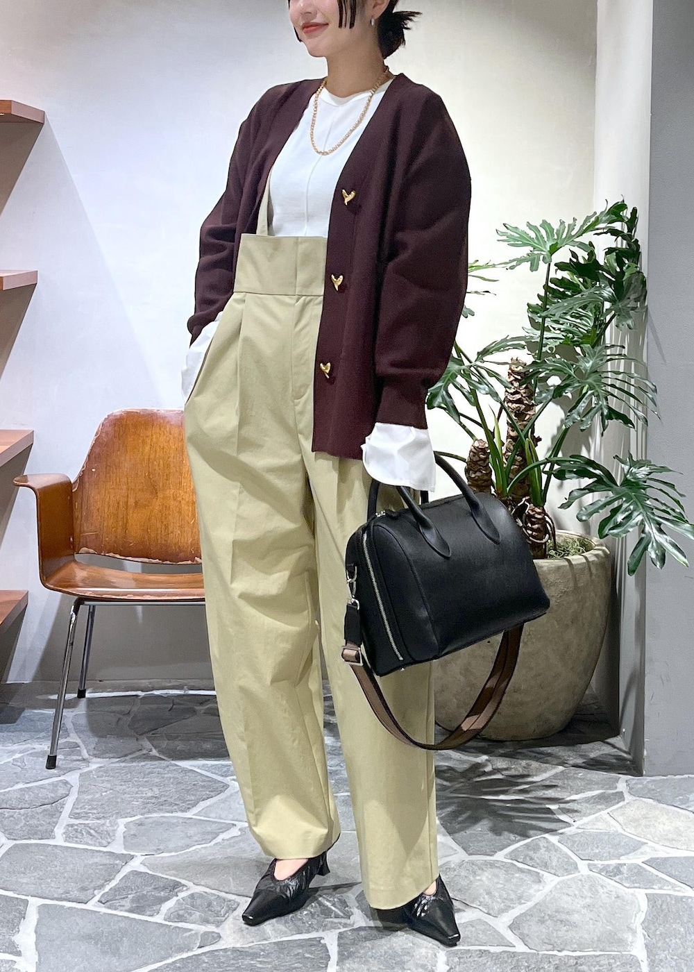 ベージュ系のサロペット/オーバーオール、ホワイト系のTシャツ/カットソー、ブラック系のボストンバッグを着用したレディースの冬コーディネートの3枚目の写真