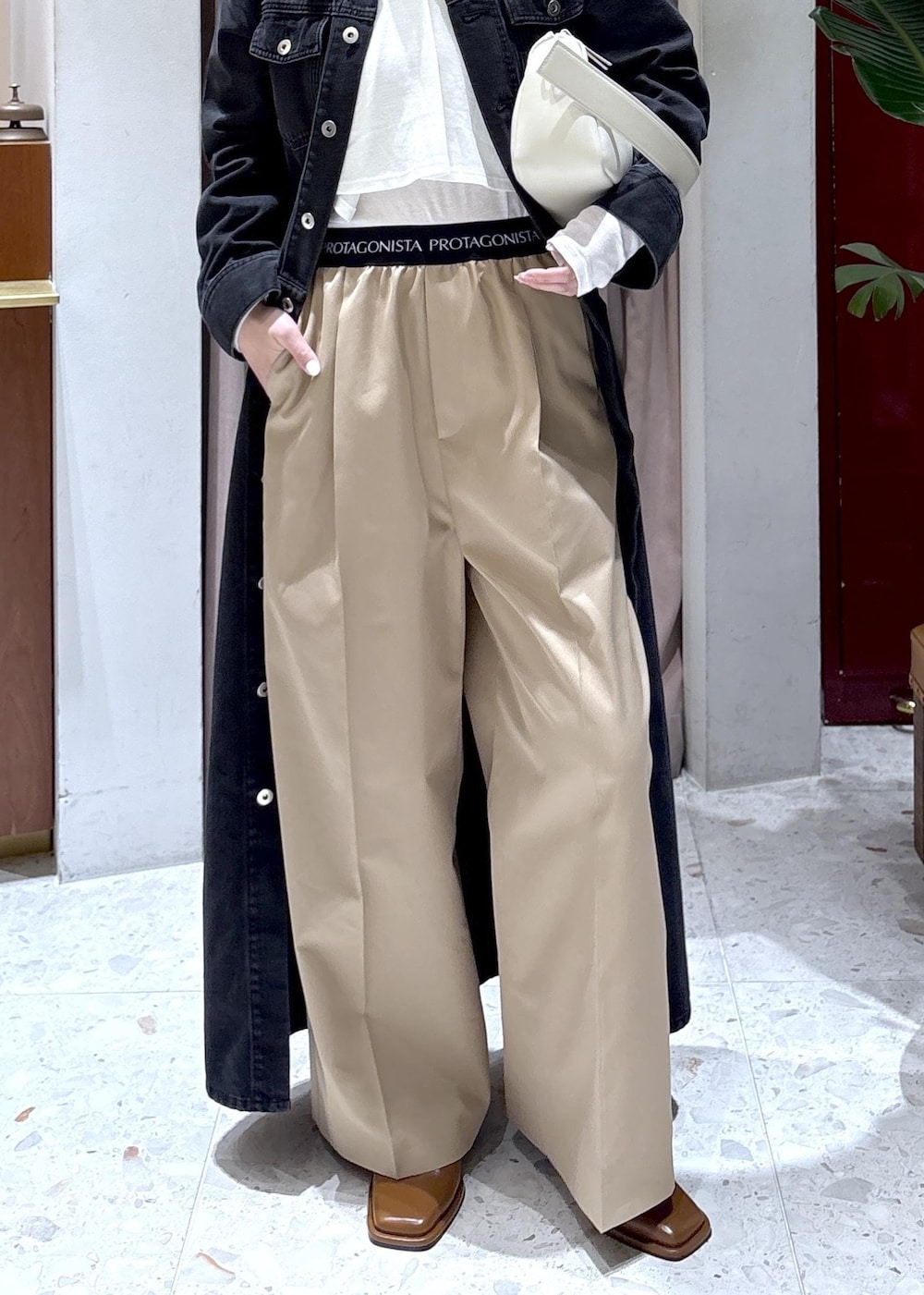 ホワイト系のハンドバッグ、ブラウン系のサンダル、ブラック系のワンピースを着用したレディースの春コーディネートの5枚目の写真