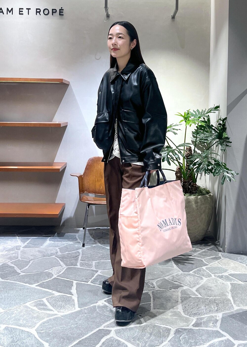 ブラック系のサンダル、ホワイト系のベスト、ブラック系のブルゾンを着用したレディースの春コーディネートの2枚目の写真