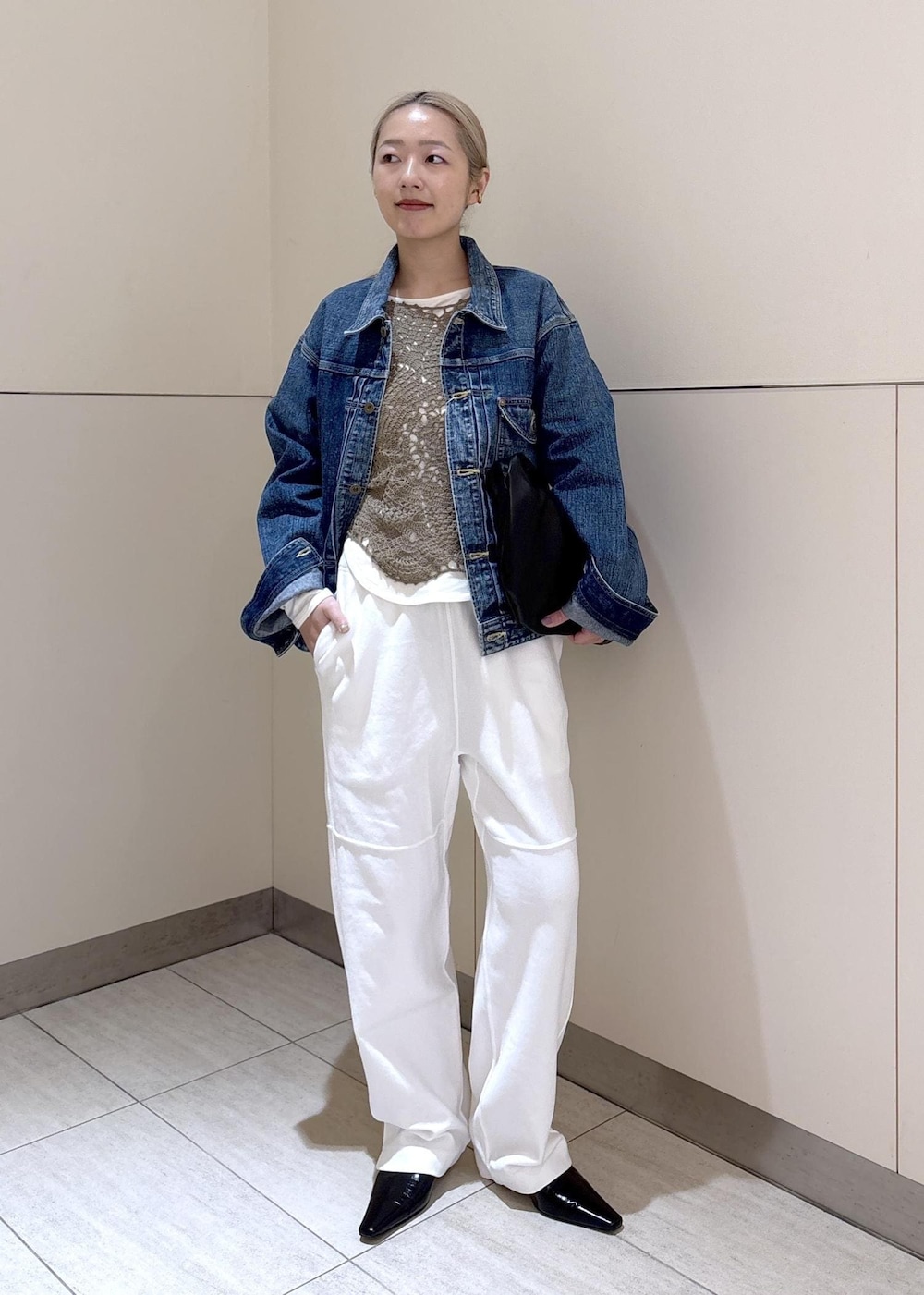 ブラック系のショルダーバッグ、ホワイト系のTシャツ/カットソー、グリーン系のキャミソールを着用したレディースの冬コーディネートの2枚目の写真