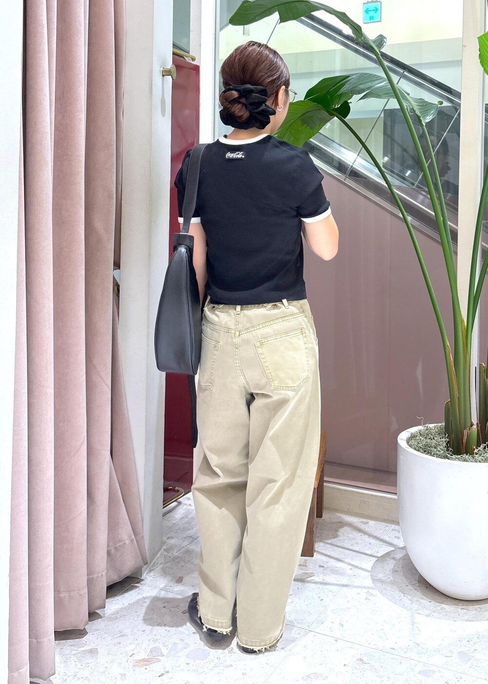 ブラック系のショルダーバッグ、ベージュ系のデニムパンツ、ブラック系のサンダルを着用したレディースの夏コーディネートの3枚目の写真