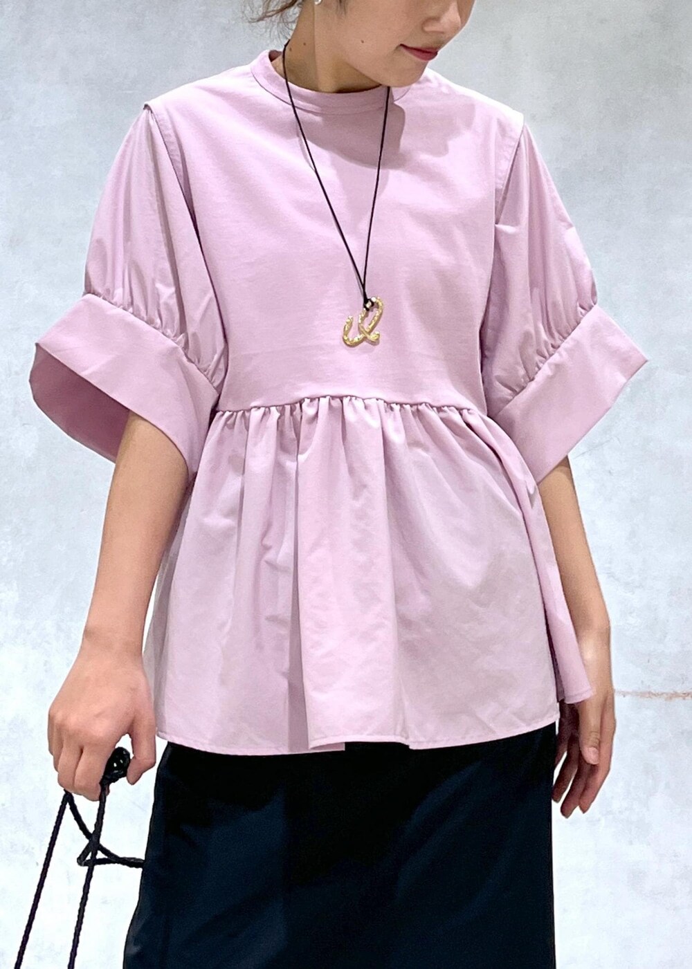 ブラック系のサンダル、ブラック系のスカート、ピンク系のTシャツ/カットソーを着用したレディースの春コーディネートの4枚目の写真