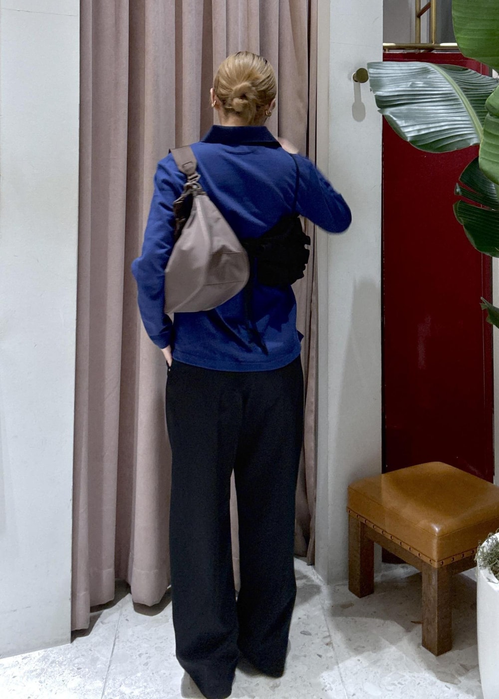 ブラウン系のショルダーバッグ、ブラック系のデニムパンツ、ブラック系のベストを着用したレディースの冬コーディネートの4枚目の写真