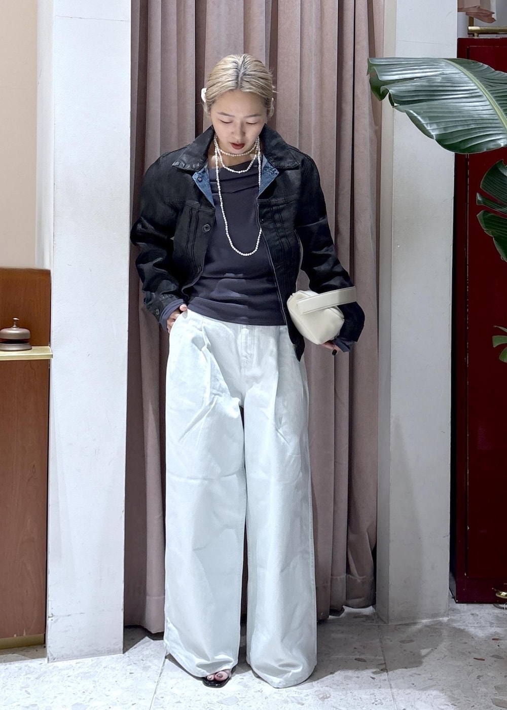 ホワイト系のハンドバッグ、グレー系のTシャツ/カットソー、ブルー系のデニムパンツを着用したレディースの冬コーディネートの4枚目の写真