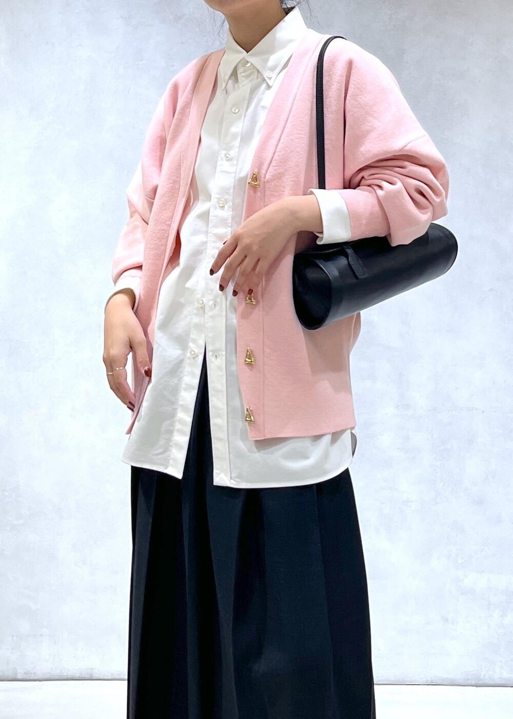 ブラック系のショルダーバッグ、ブラック系のブーツ、ピンク系のカーディガン/ボレロを着用したレディースの秋コーディネートの4枚目の写真